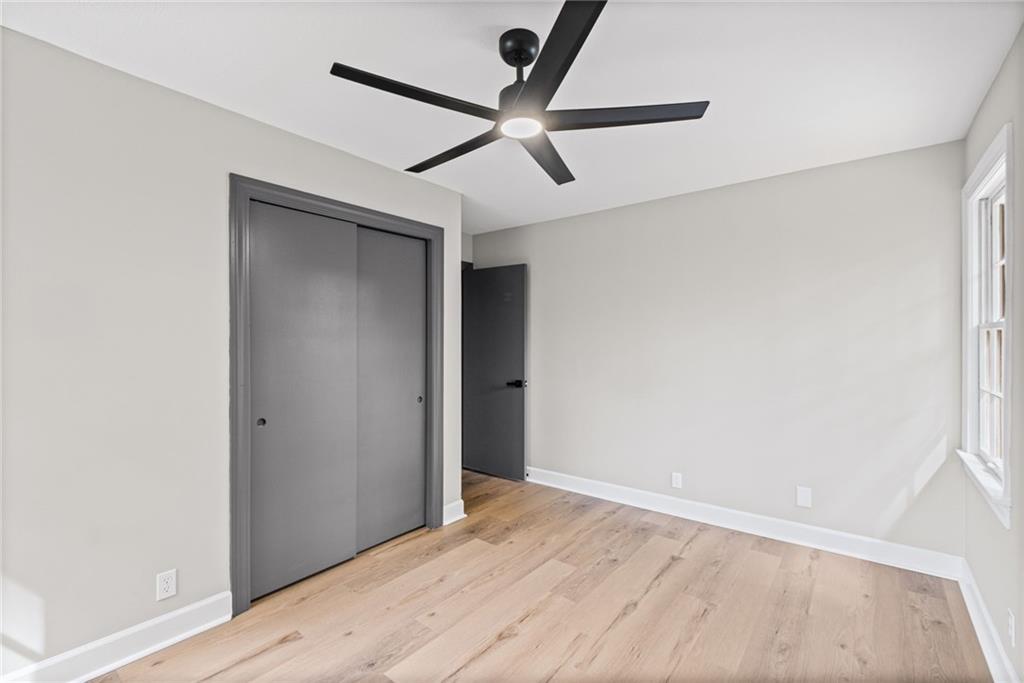 7 East Creekview Drive Southwest Rome, GA 30165 - Photo 23 of 43 an empty room with a ceiling fan and wooden floor