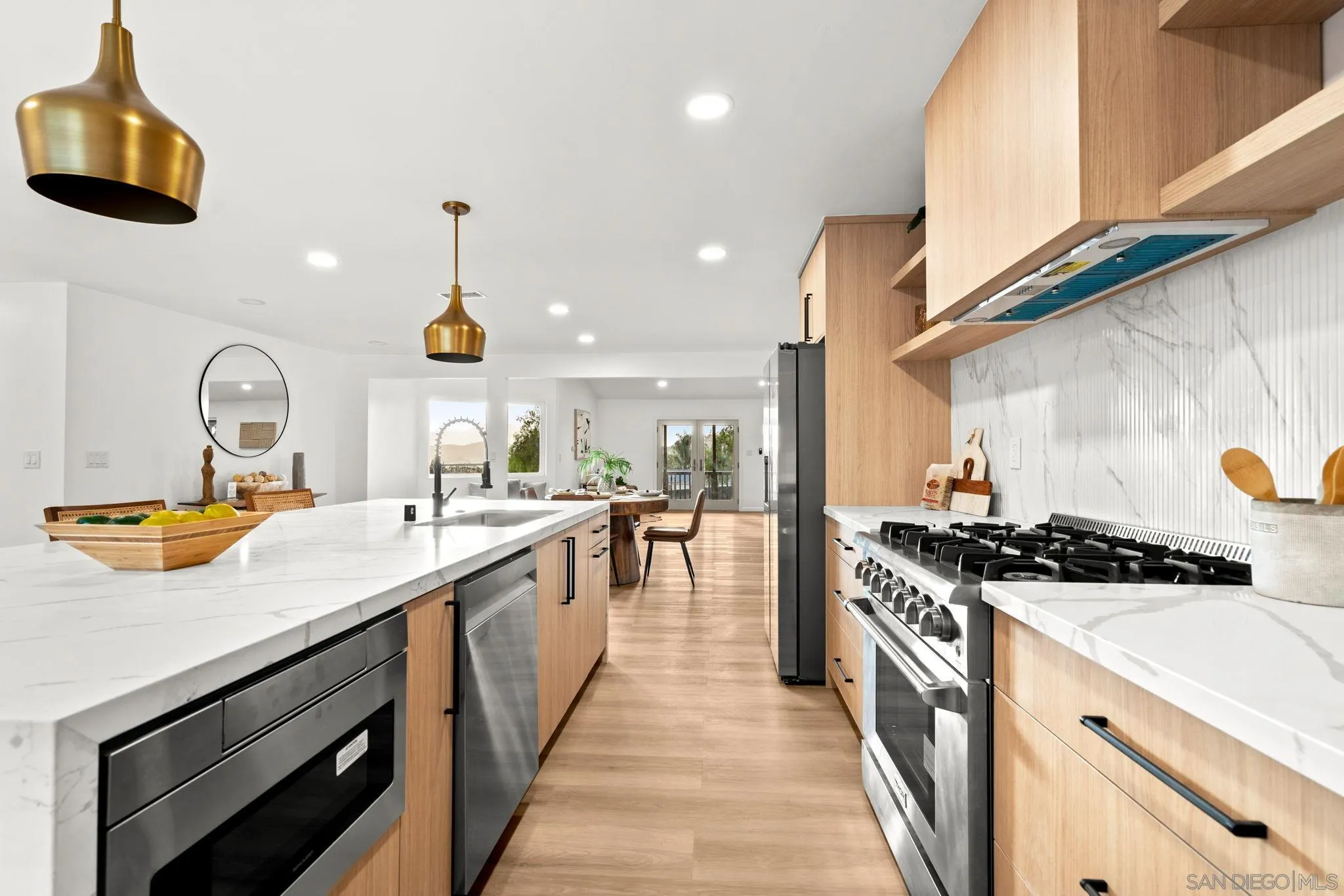 a kitchen with stainless steel appliances a sink a stove and cabinets