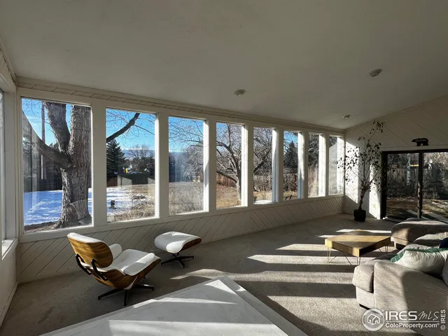 a living room with furniture and floor to ceiling windows