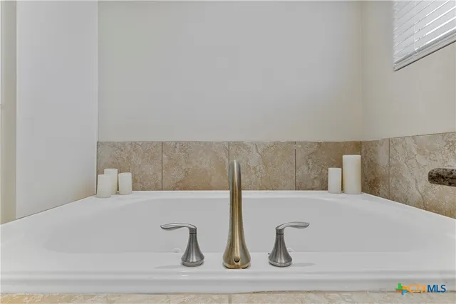 a bathroom with a granite countertop sink and white cabinets