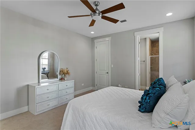 a bedroom with a large bed and a ceiling fan