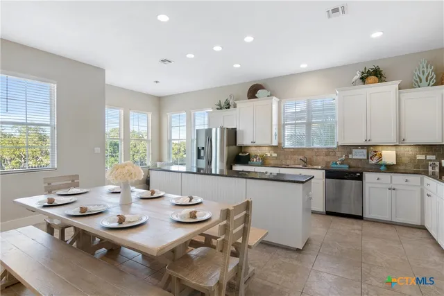a open dining room with stainless steel appliances furniture a window and kitchen view