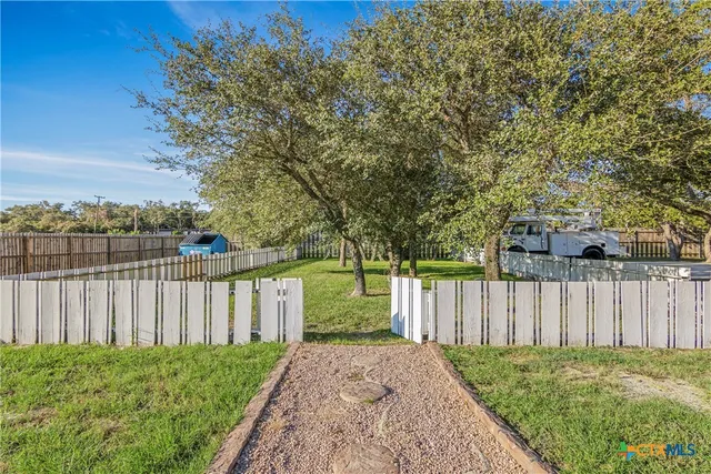a view of a white house with a fountain and a fire pit