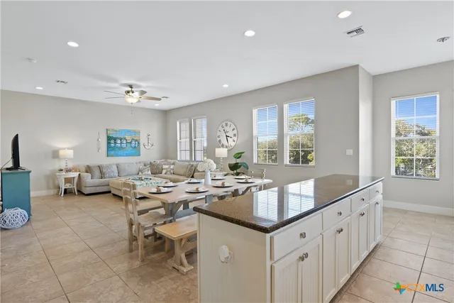 a large dining hall with stainless steel appliances granite countertop a sink and dishwasher
