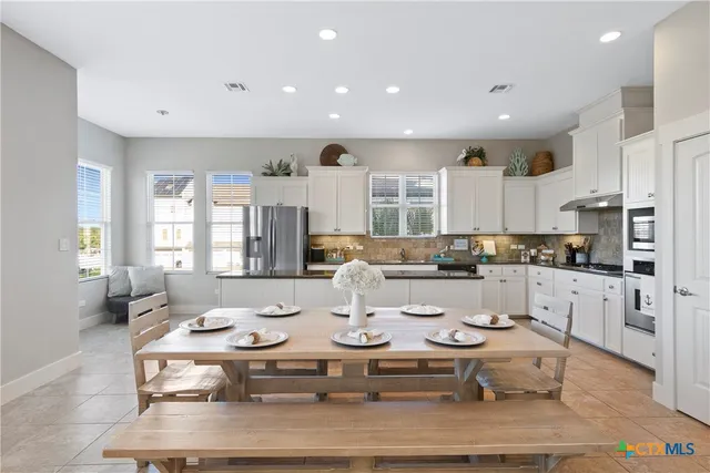 a large kitchen with a table and chairs