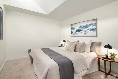 a bedroom with a bed and a painting on the wall