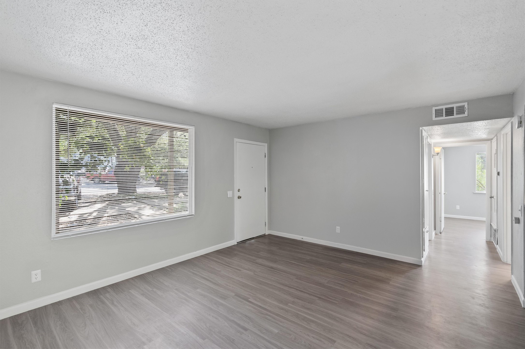 2501 Manor Circle, Unit B Austin, TX 78723 - Photo 2 of 17 a view of an empty room with wooden floor and a window