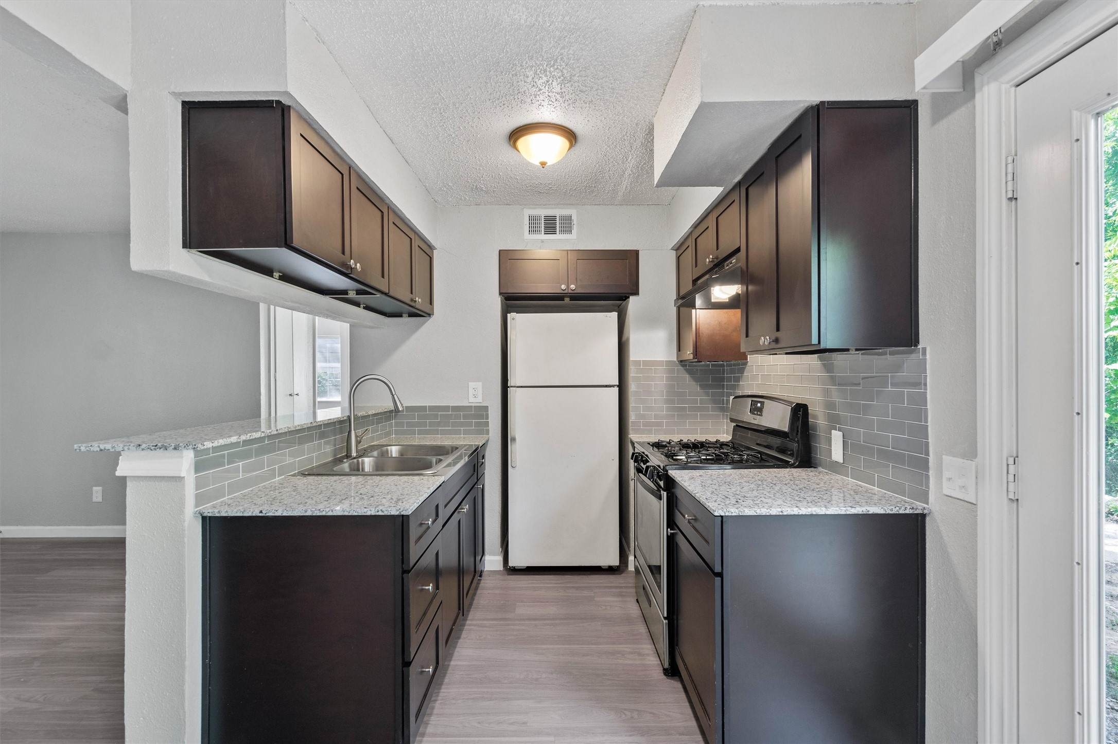 2501 Manor Circle, Unit B Austin, TX 78723 - Photo 6 of 17 a kitchen with stainless steel appliances granite countertop a sink stove and refrigerator