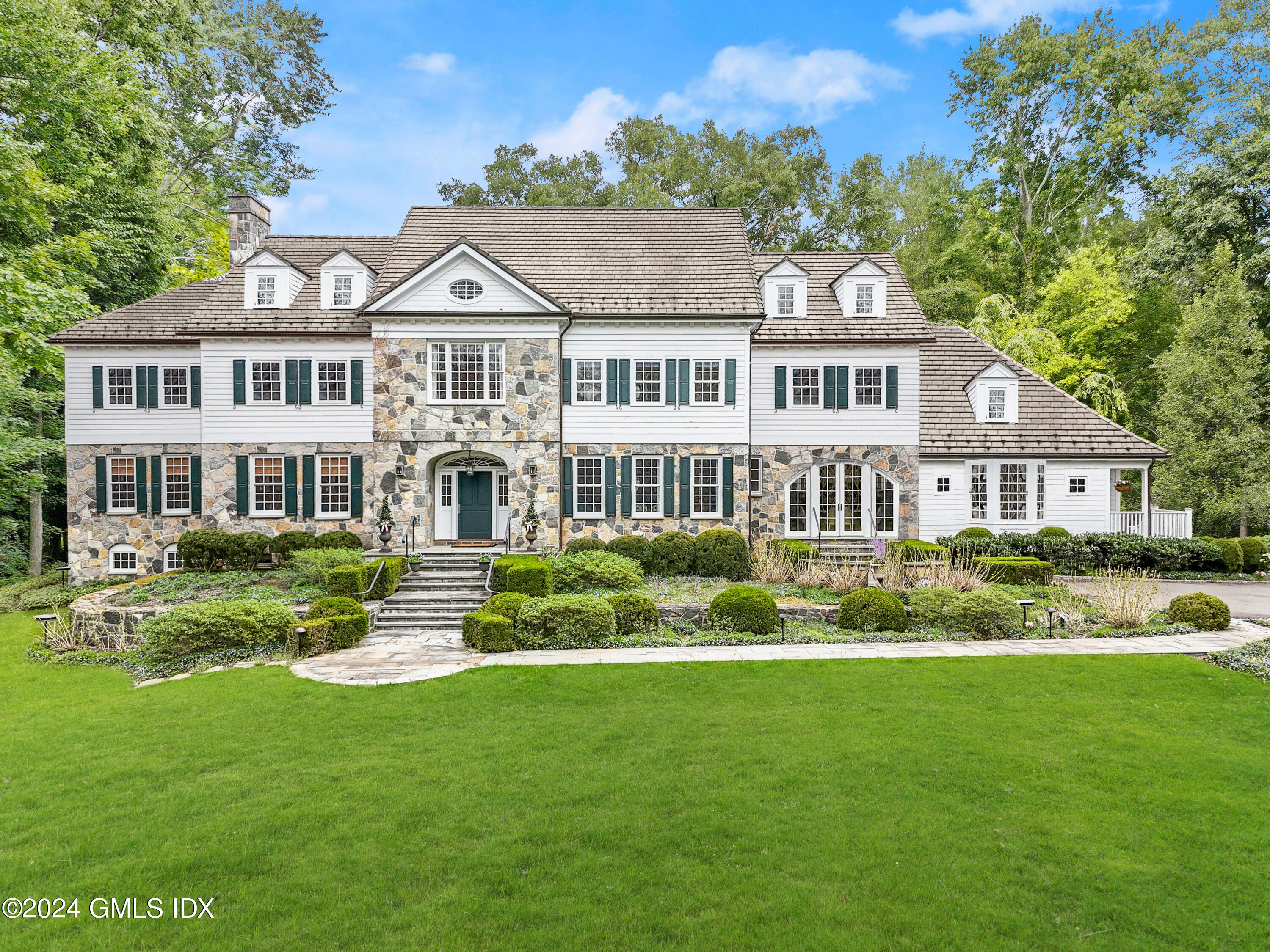 68 Rock Maple Road Greenwich, CT 06830 - Photo 1 of 46 a front view of a house with a garden