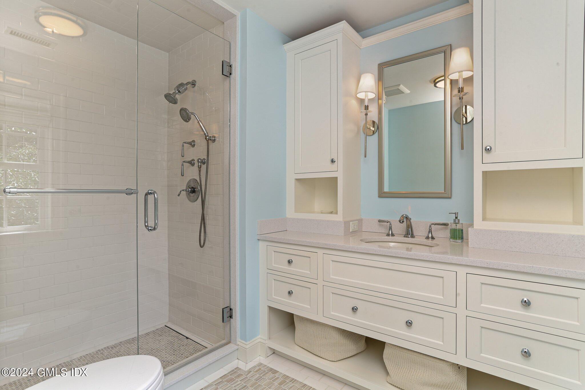68 Rock Maple Road Greenwich, CT 06830 - Photo 26 of 46 a bathroom with a double vanity sink toilet mirror and shower