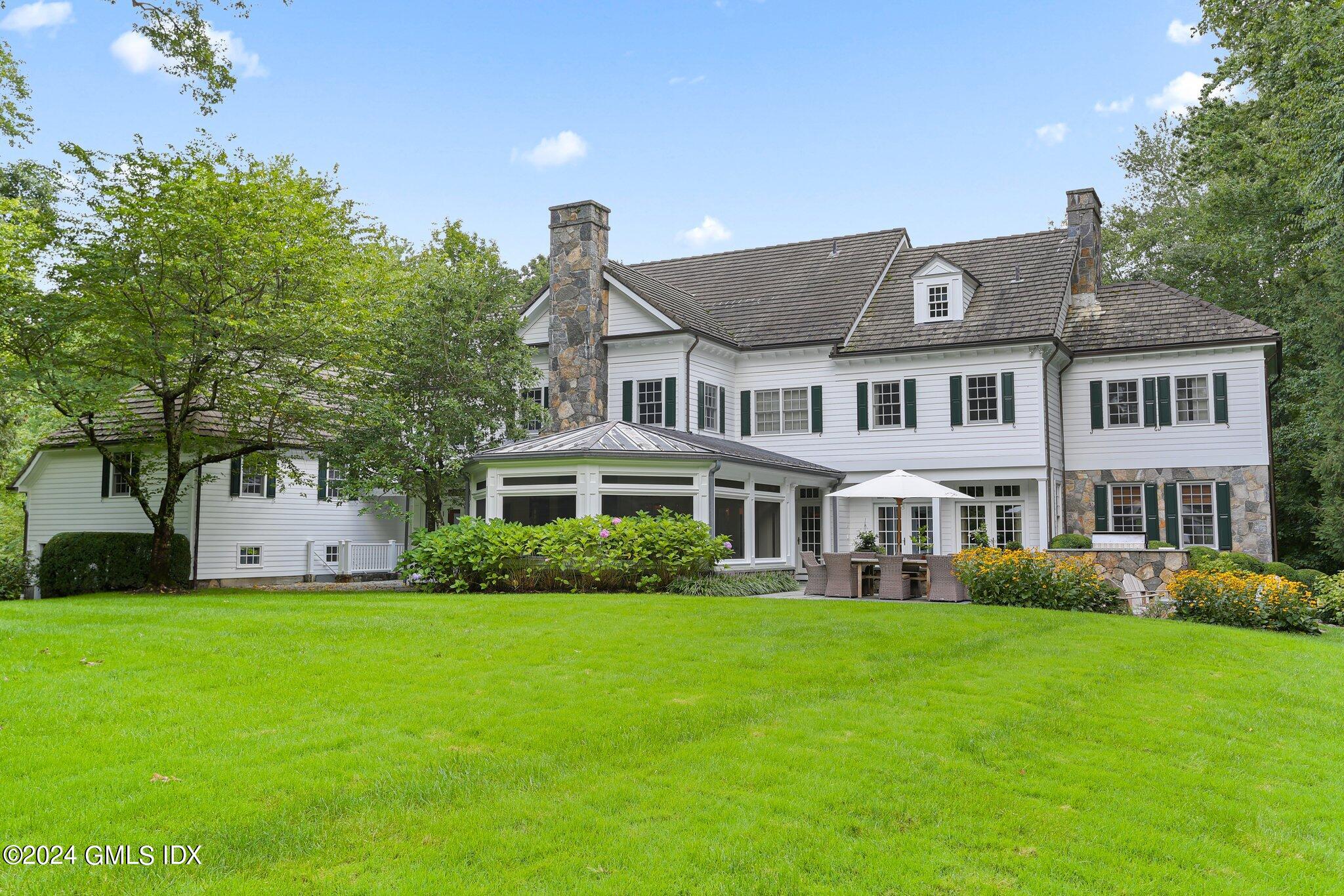 68 Rock Maple Road Greenwich, CT 06830 - Photo 35 of 46 a front view of a house with a garden and trees