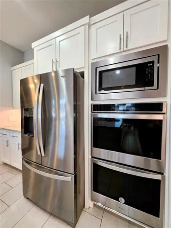 a metallic refrigerator freezer sitting in a kitchen