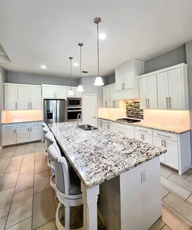 a kitchen with stainless steel appliances granite countertop a table chairs sink and cabinets