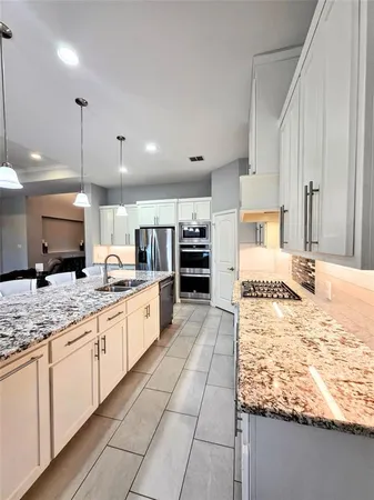 a large kitchen with kitchen island granite countertop a large counter top and stainless steel appliances