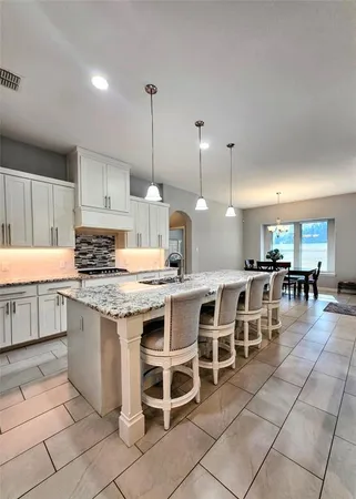 a kitchen with cabinets and chairs