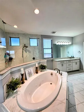 a bathroom with a tub sink and mirror