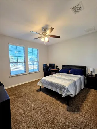 a spacious bedroom with a bed a chandelier and a window