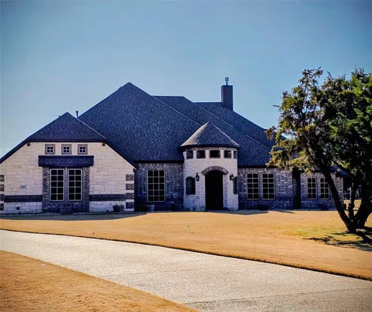 a front view of a house with large trees
