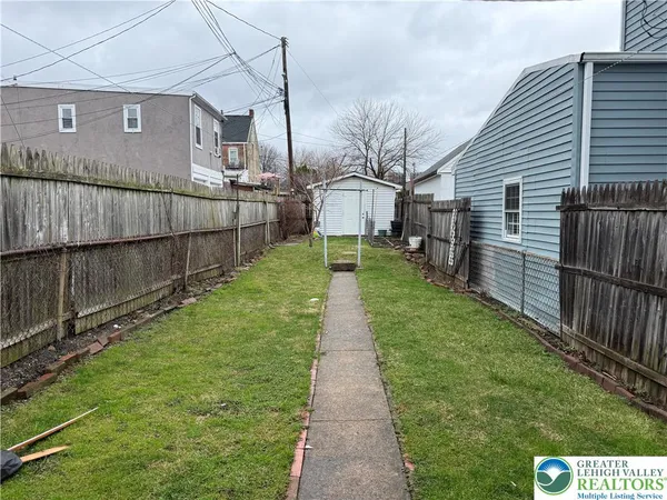 a view of a backyard with wooden fence