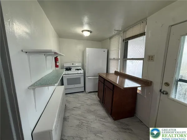 a kitchen with refrigerator cabinets and wooden floor