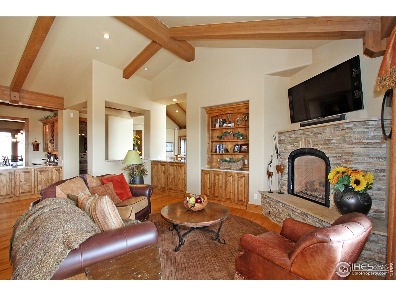 9455 Crystal Lane Longmont, CO 80503 - Photo 16 of 40 a living room with furniture a flat screen tv and kitchen view