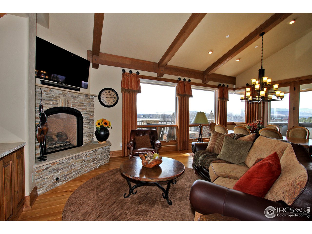 9455 Crystal Lane Longmont, CO 80503 - Photo 17 of 40 a living room with furniture a fireplace and a flat screen tv