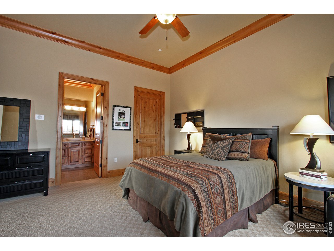 9455 Crystal Lane Longmont, CO 80503 - Photo 22 of 40 a bedroom with a bed and dresser with mirror