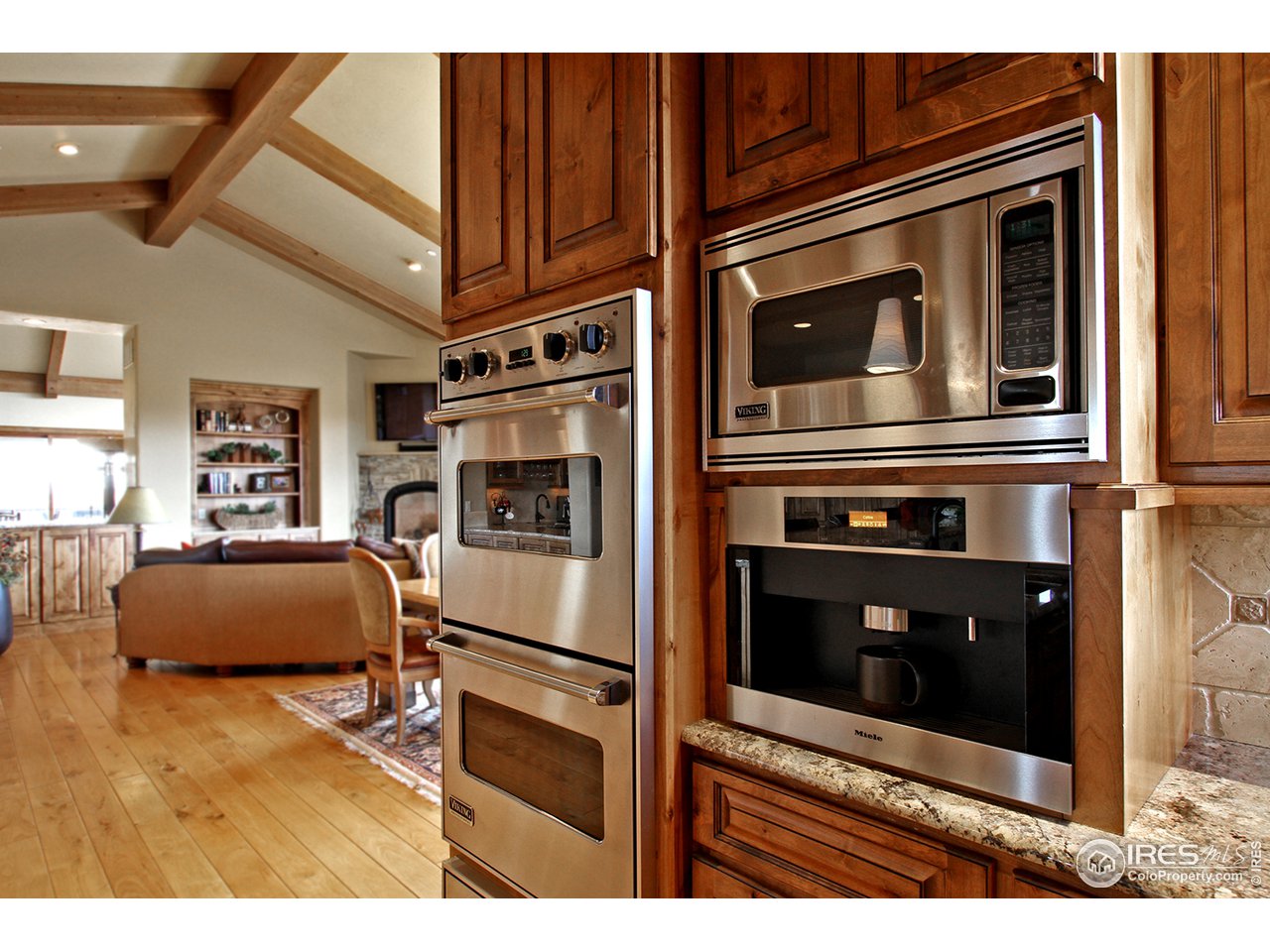 9455 Crystal Lane Longmont, CO 80503 - Photo 9 of 40 a kitchen with stainless steel appliances kitchen island granite countertop a stove microwave and refrigerator