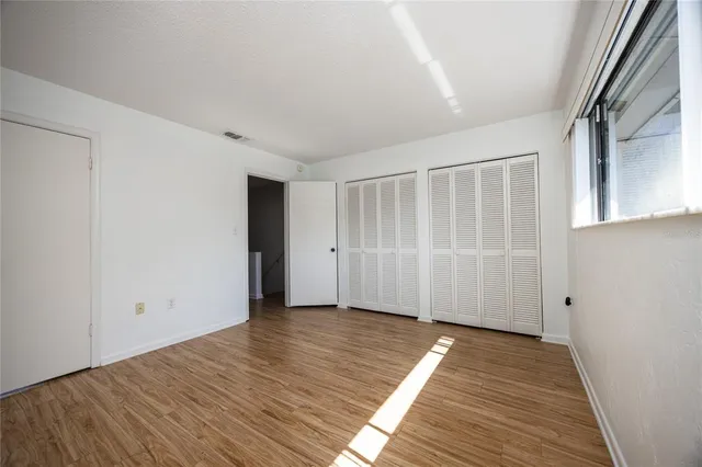 a view of an empty room with wooden floor