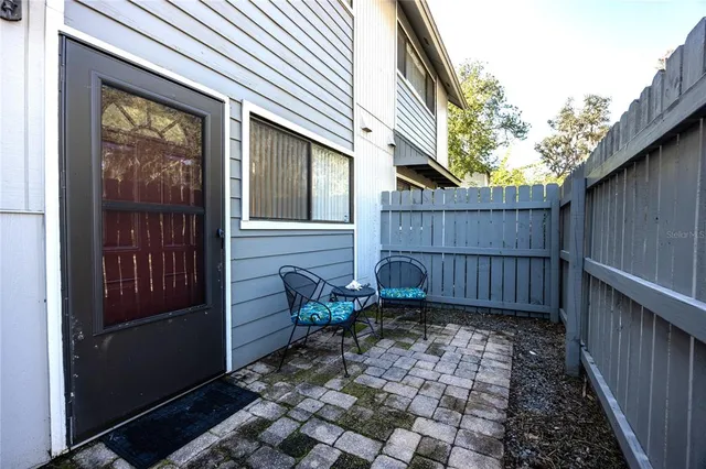 a view of a house with a small yard and wooden fence