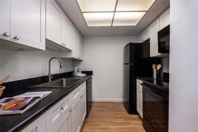 a kitchen with granite countertop a refrigerator and a sink