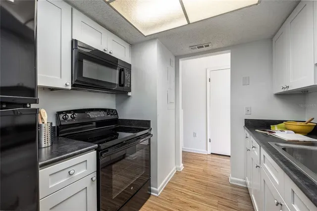a kitchen with stainless steel appliances granite countertop a stove and a microwave
