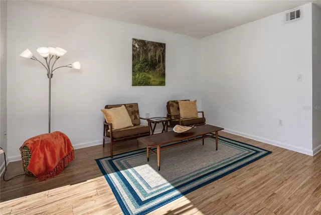 a living room with furniture rug and wooden floor