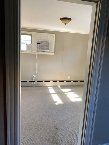 a view of a room with an empty space and window