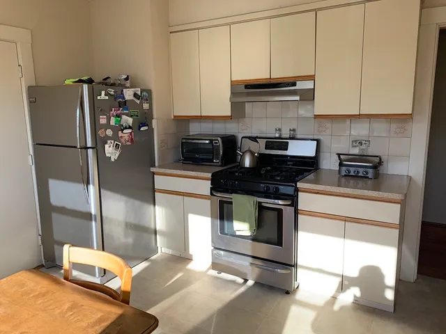a kitchen with a refrigerator and a stove top oven