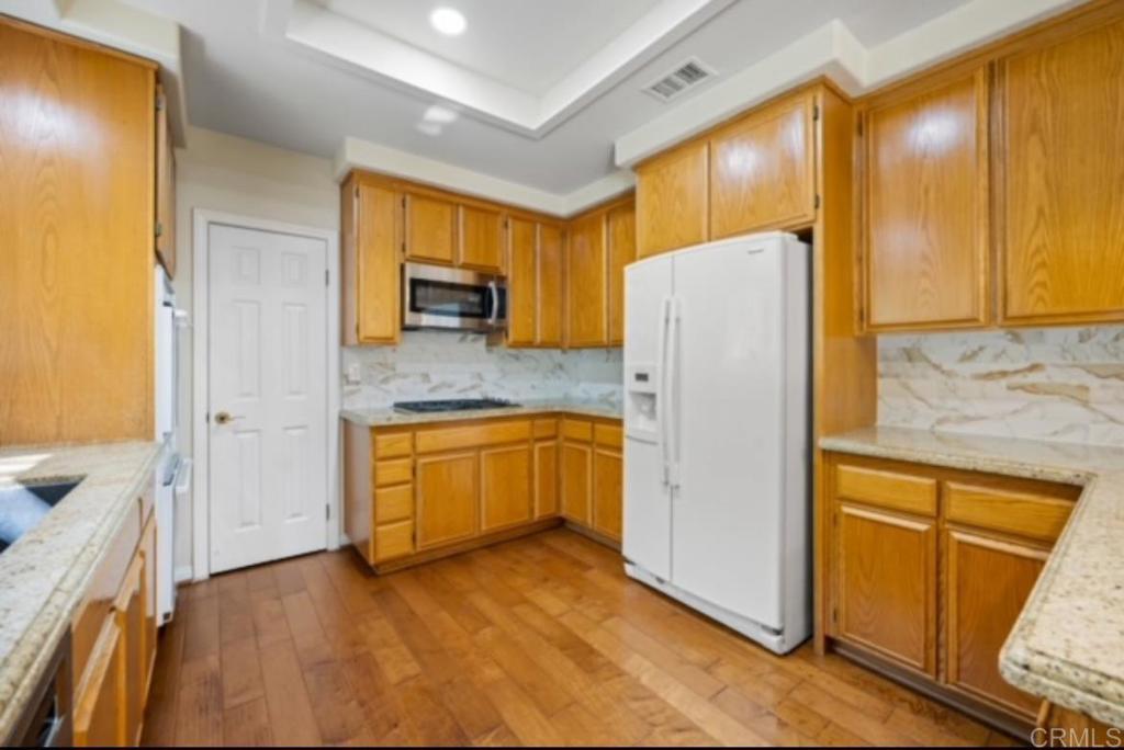 4009 Pala Mesa Oaks Drive Fallbrook, CA 92028 - Photo 12 of 45 a kitchen with a refrigerator sink and cabinets