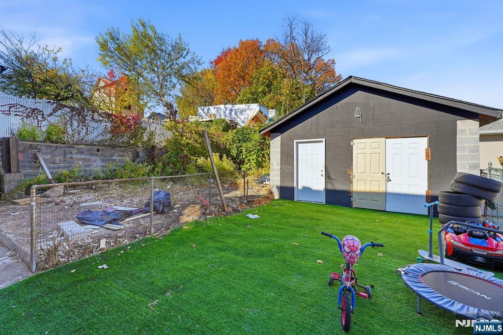 20 Wickham Street Passaic, NJ 07055 - Photo 19 of 20 a backyard of a house with table and chairs plants and large tree