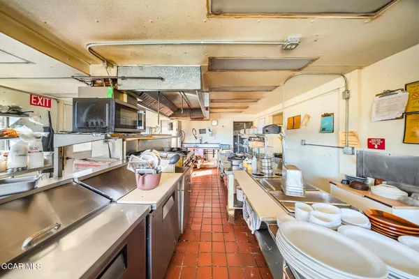 a view of a hallway with wooden floor and dining room