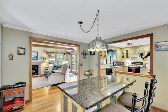 a dining room with furniture a chandelier and wooden floor