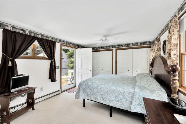 a bedroom with a bed a mirror and a window