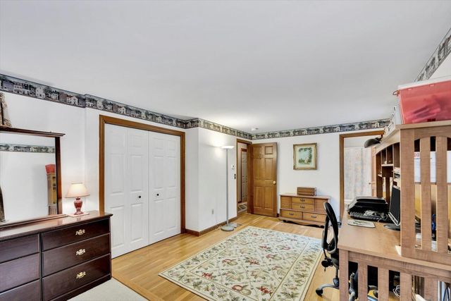 a spacious bedroom with a bed and a dresser in it