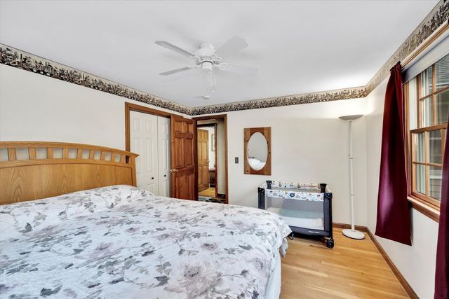 a bedroom with a bed and a dresser with mirror