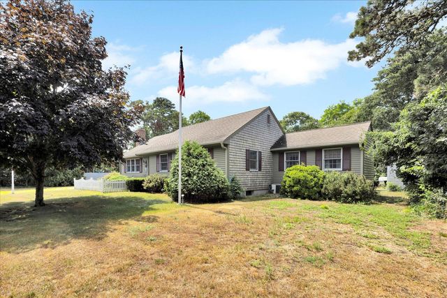 a front view of house with yard and trees around