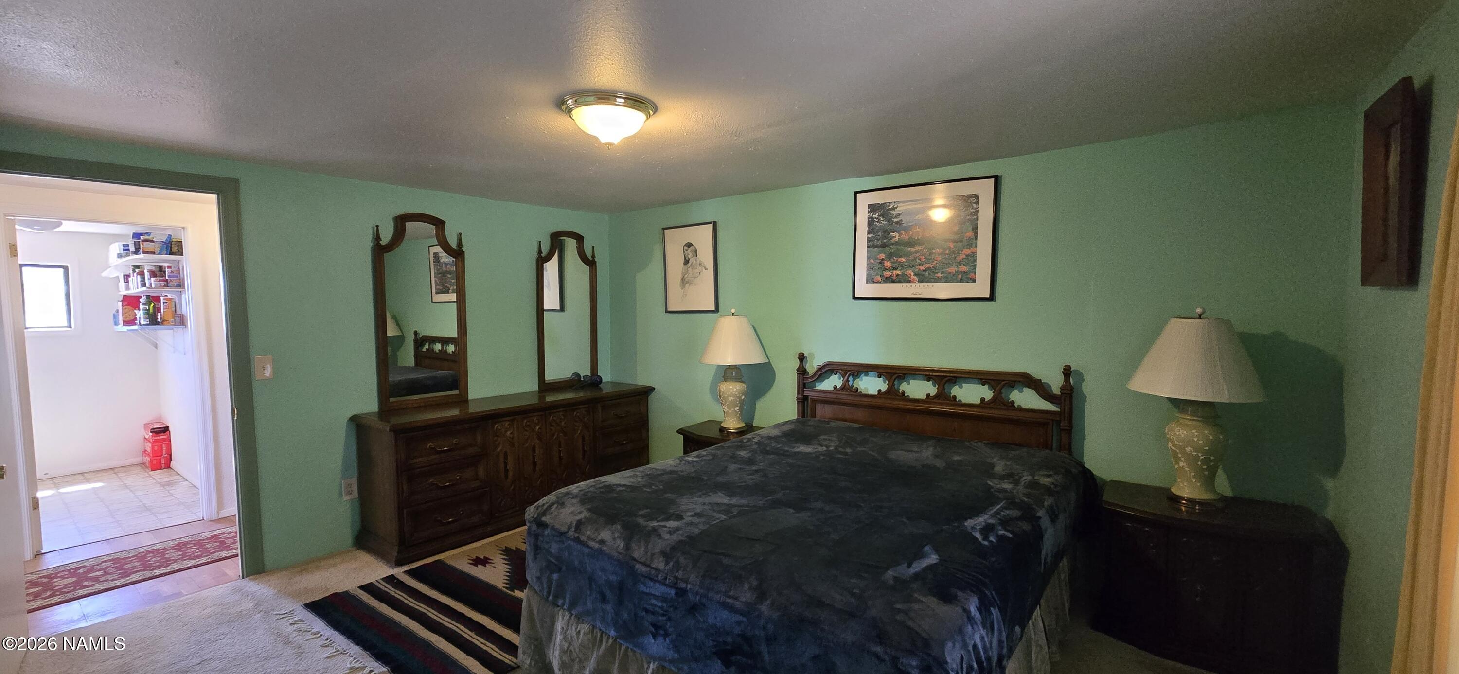 2795 Poppy Road Ash Fork, AZ 86320 - Photo 15 of 56 a bedroom with a bed and a dresser in it