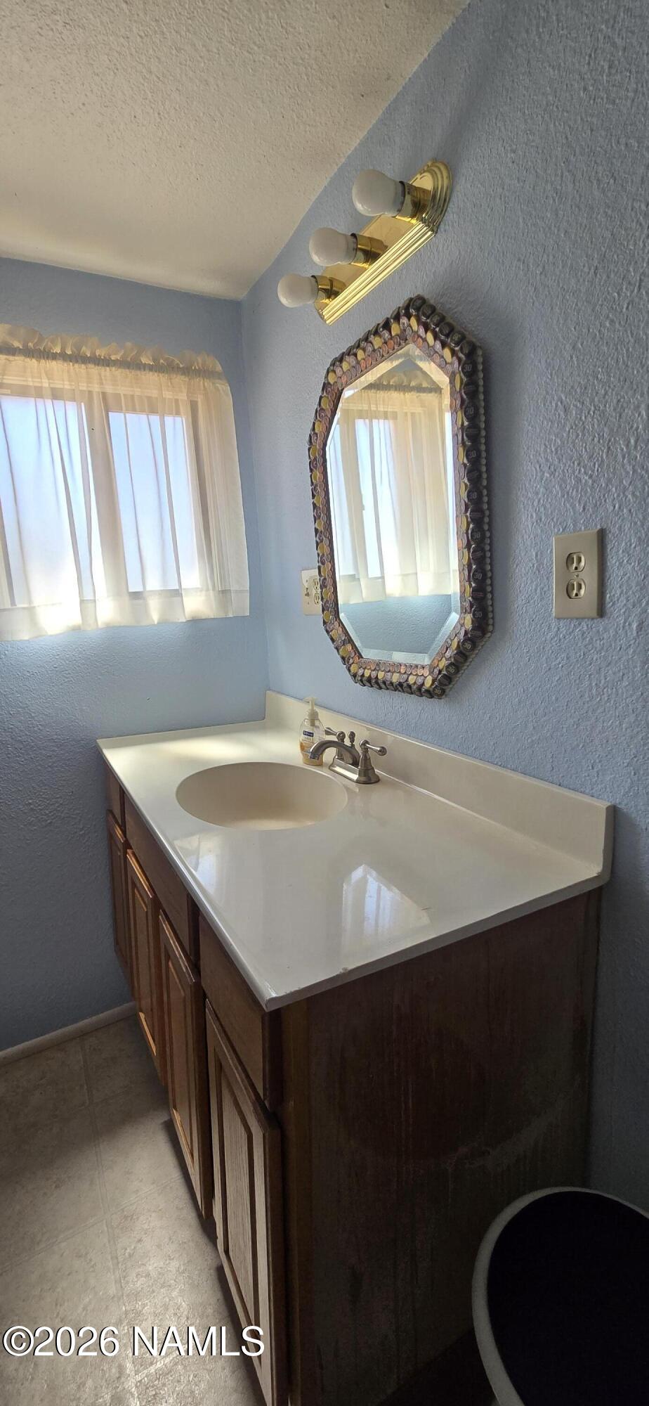2795 Poppy Road Ash Fork, AZ 86320 - Photo 19 of 56 a bathroom with a sink a mirror and a vanity