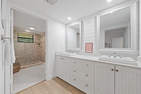 a bathroom with double sink and a mirror