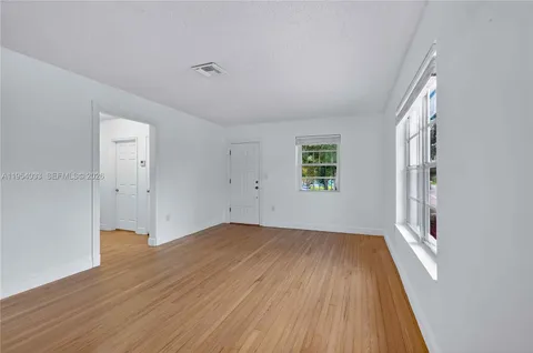 wooden floor in an empty room with a window