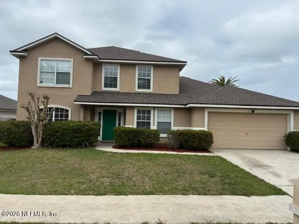 a front view of a house with a yard and garage