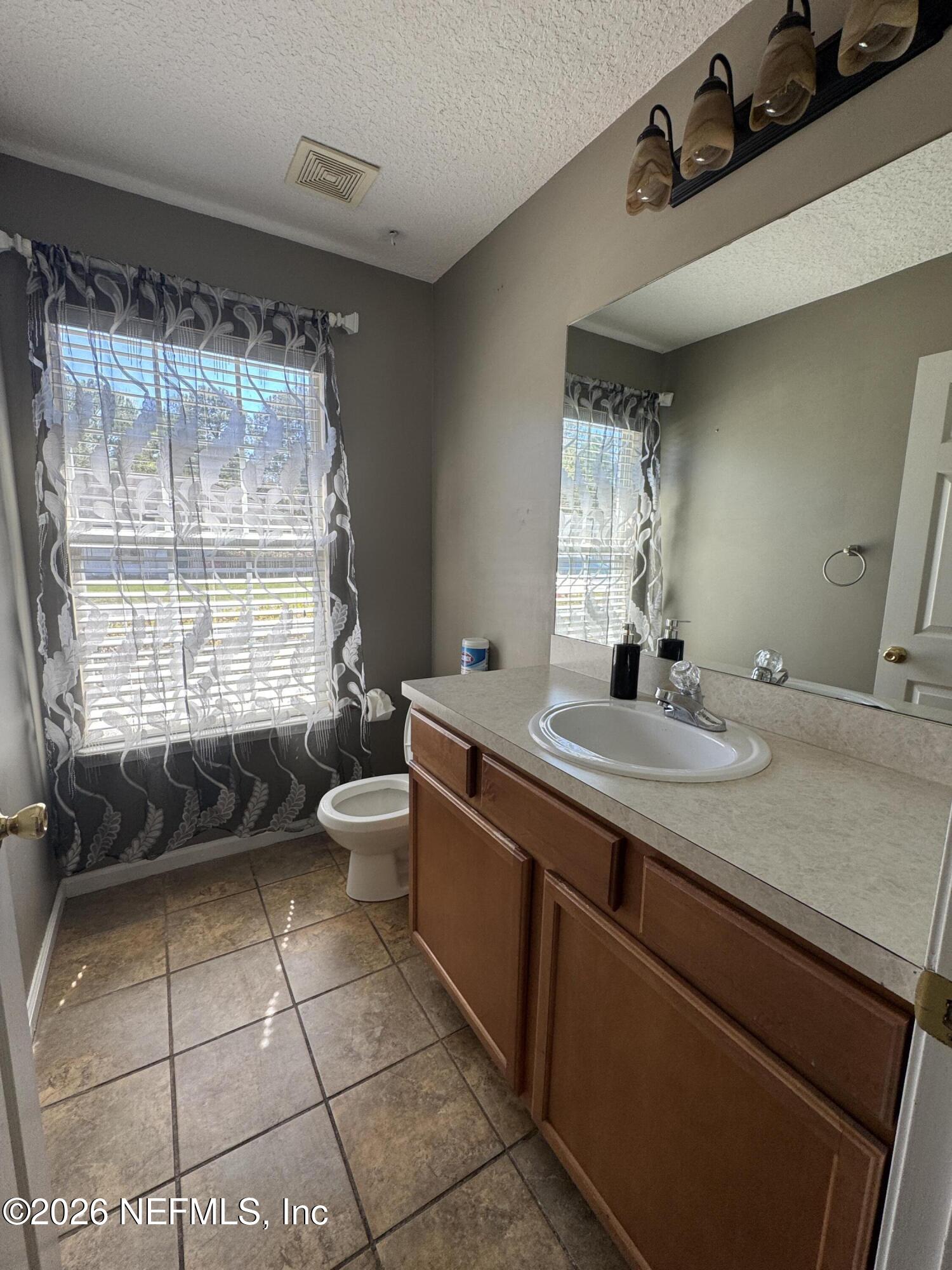 2725 Ravine Hill Drive Middleburg, FL 32068 - Photo 20 of 23 a bathroom with a double vanity sink toilet and a mirror