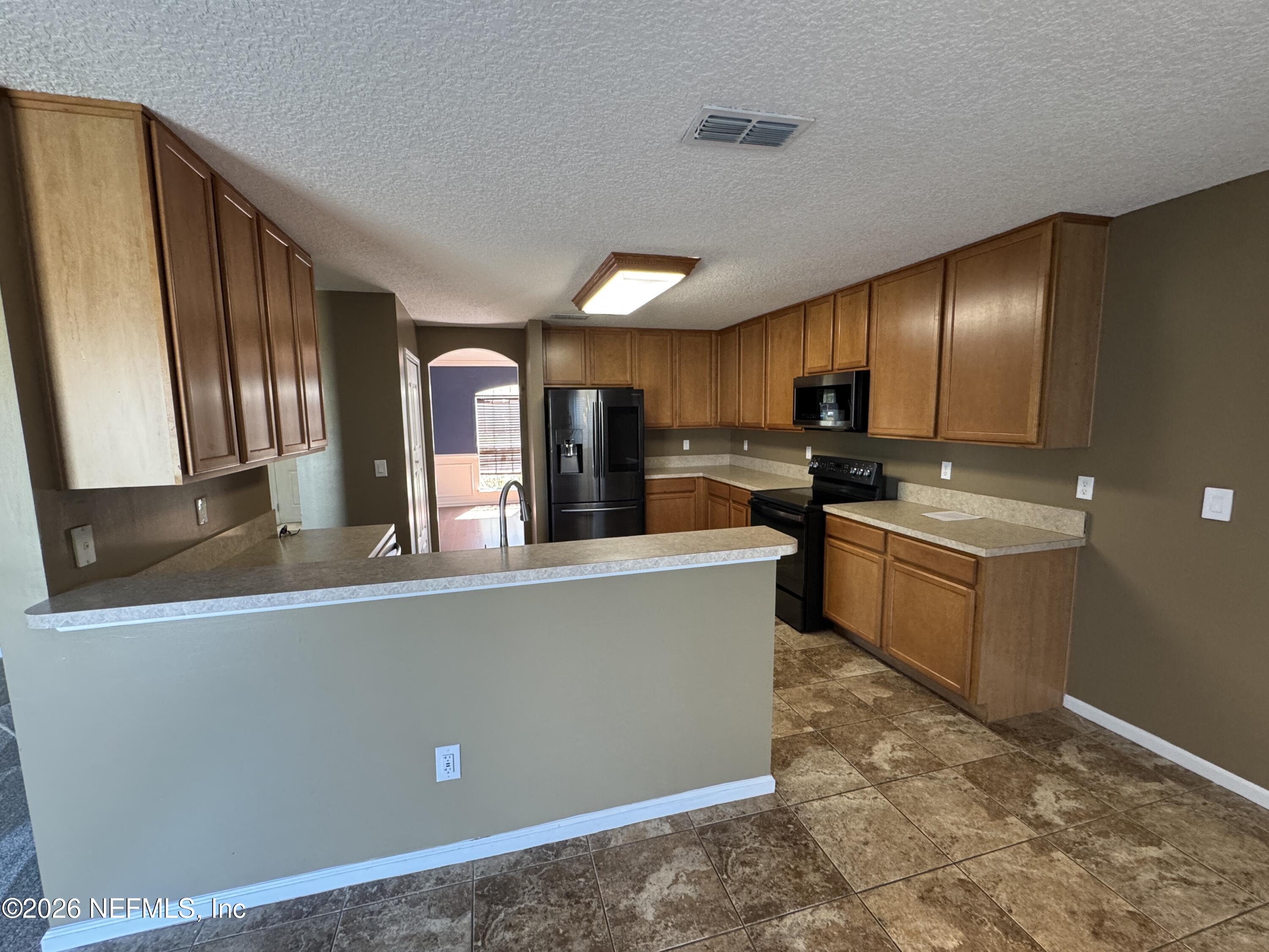 2725 Ravine Hill Drive Middleburg, FL 32068 - Photo 5 of 23 a kitchen with stainless steel appliances granite countertop a refrigerator a stove top oven a sink and dishwasher